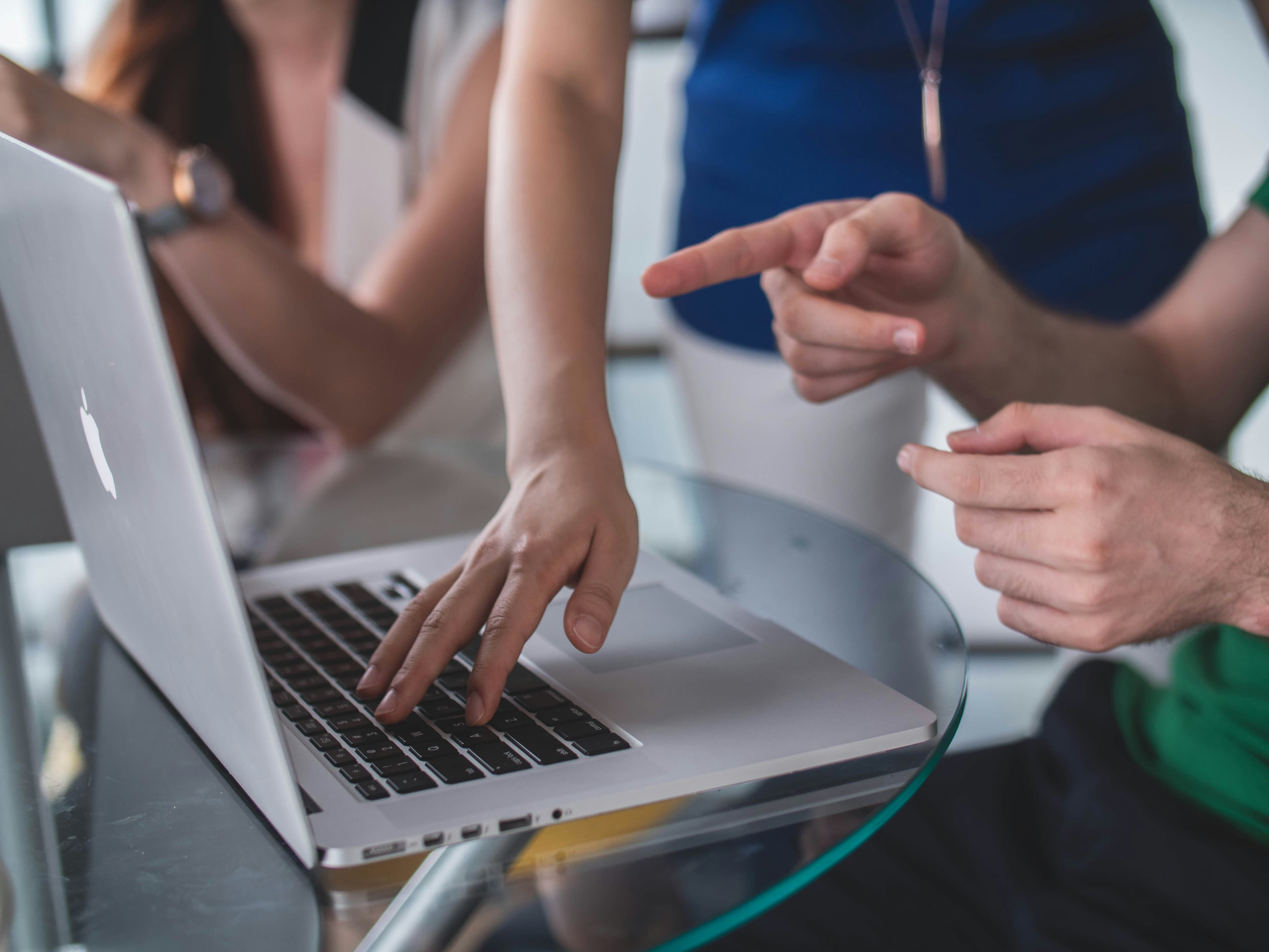 Designer pointing at a website design on a laptop